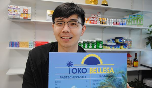 Baolin Zhen met de menukaart van Toko Bellesa in de winkel
